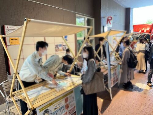 ASTERフェスティバル2022 の会場で、学生がブースの担当者と話している様子