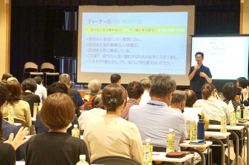まちのコラボステーション きたじま オープニングイベント(2023年9月14日・北島町)の講演。スクリーンにスライドを映して話している様子