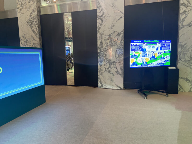 グラフィックレコーディング ServiceNow World Forum Tokyo 2024 会場。モニターに描いたグラフィックレコーディングが表示されている