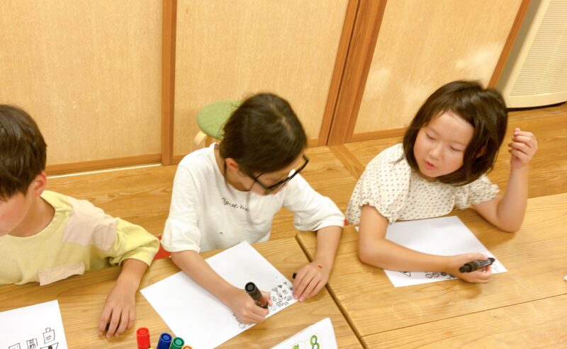 小学生向けグラレコ講座 で、子どもたちが机に向かって描いている様子