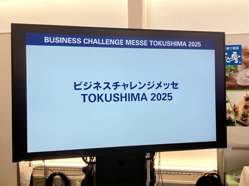 会場のモニターに映る「ビジネスチャレンジメッセ TOKUSHIMA 2025」のタイトル画面